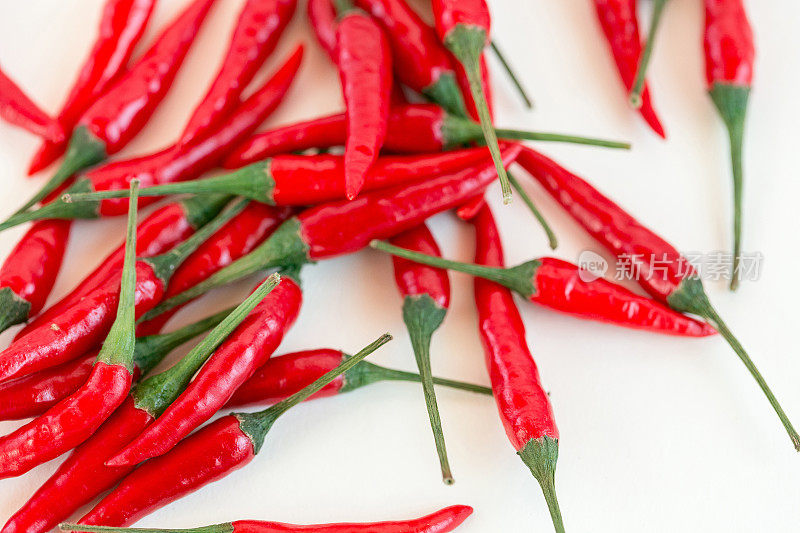 红辣椒，流行的香料概念-美丽的红辣椒，豆荚自由散落在白色的背景，俯视图，平铺，孤立