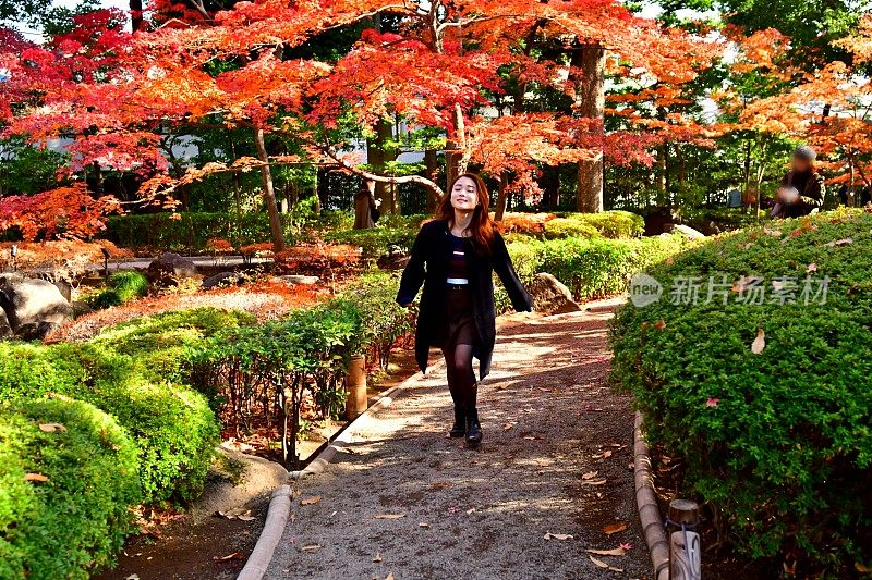 年轻的日本女子在秋叶公园跑步