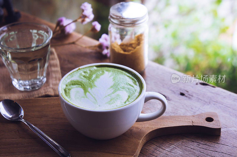 木桌上的绿茶热饮拿铁白杯，香气袭人，咖啡厅休闲时光