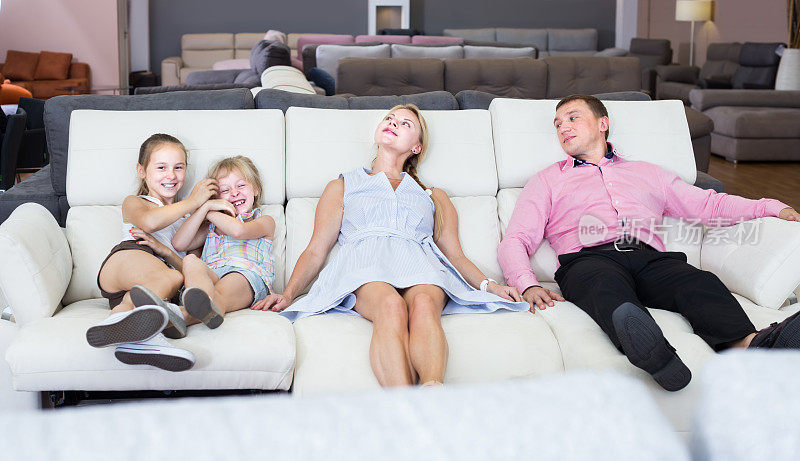 幸福的家庭和孩子们选择新的沙发变压器