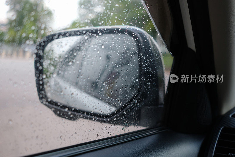 靠近车窗上的雨滴，雨后透过镜子背景与自然景观
