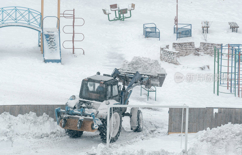 拖拉机清理操场上的溜冰场积雪