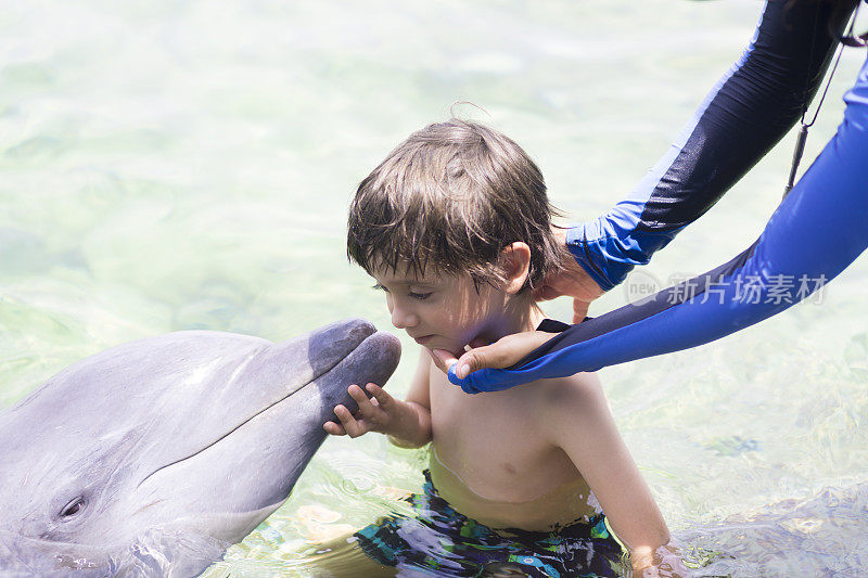 假期生活方式-快乐男孩拥抱海豚