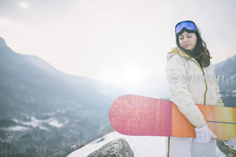 冬天穿着滑雪服的女人靠近滑雪板