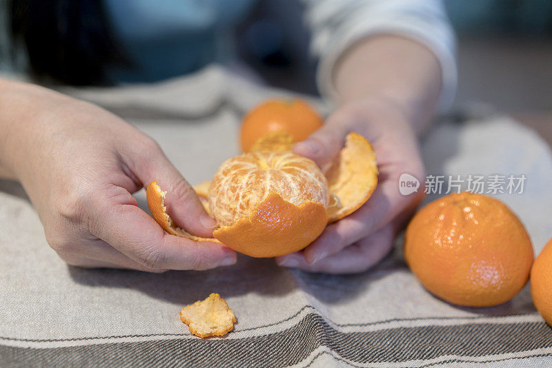女孩正在剥新鲜的橘子
