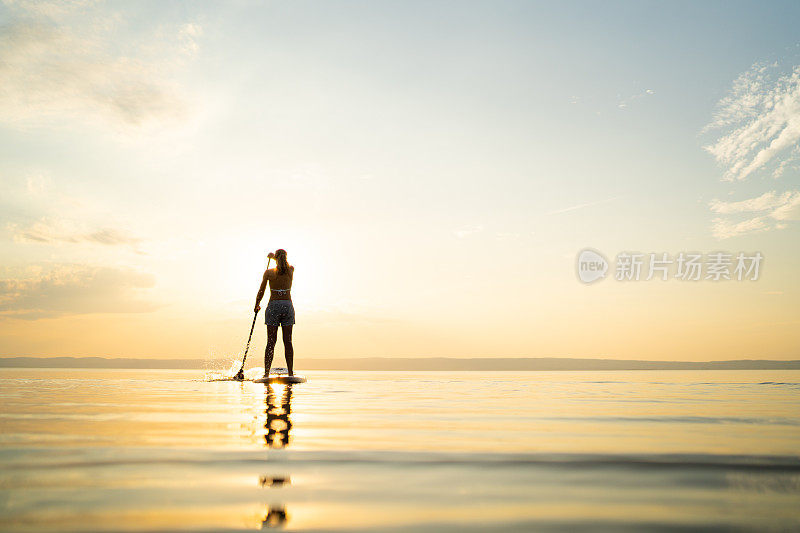 日落时分，一个人在空旷的湖面上划桨