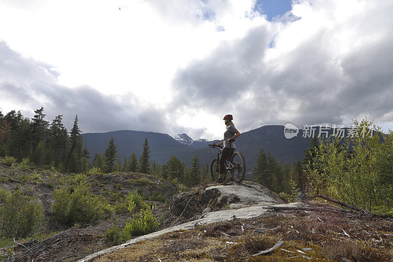 女山地自行车手停下来观看加拿大沿海的山脉