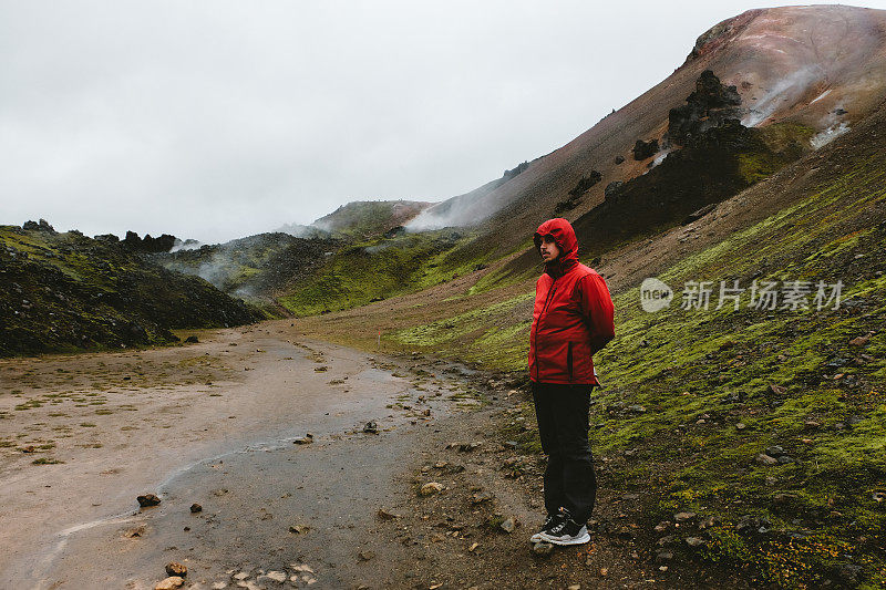 红色的男人在冰岛高地的地热地区徒步旅行