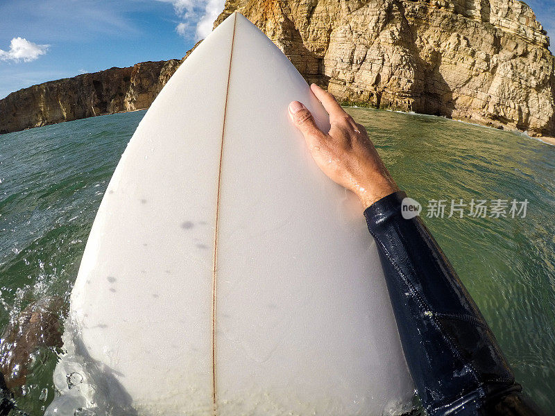 冲浪者在水中举着冲浪板