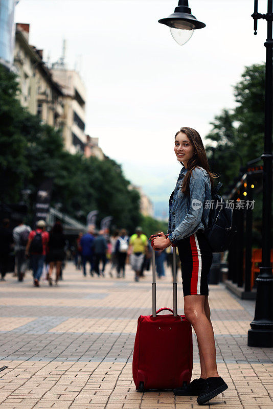 带着行李箱微笑的漂亮女孩