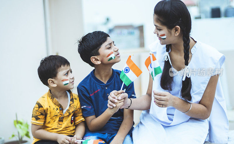 快乐的印度少女和两个小男孩举着印度国旗自豪