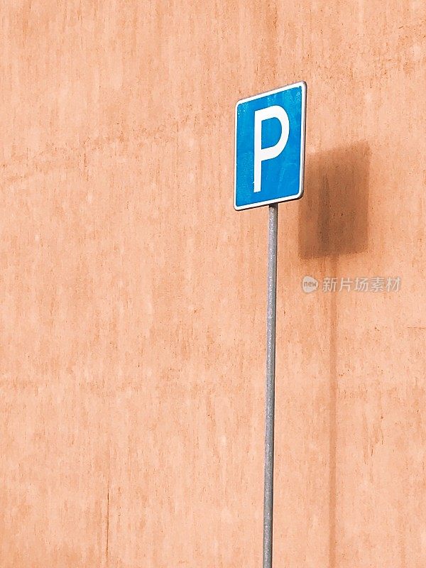 桃树墙前的蓝色停车标志
