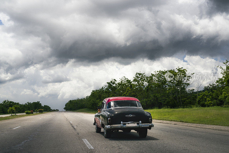 鲜艳的旧红色美国1950年的汽车在老哈瓦那区经过