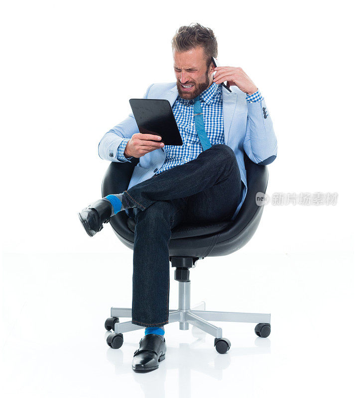 白人男性商人穿着衬衫坐在那里使用数码平板电脑