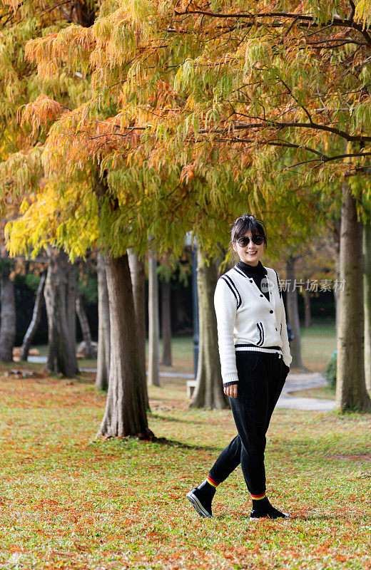 在秋天的公园里散步的女人