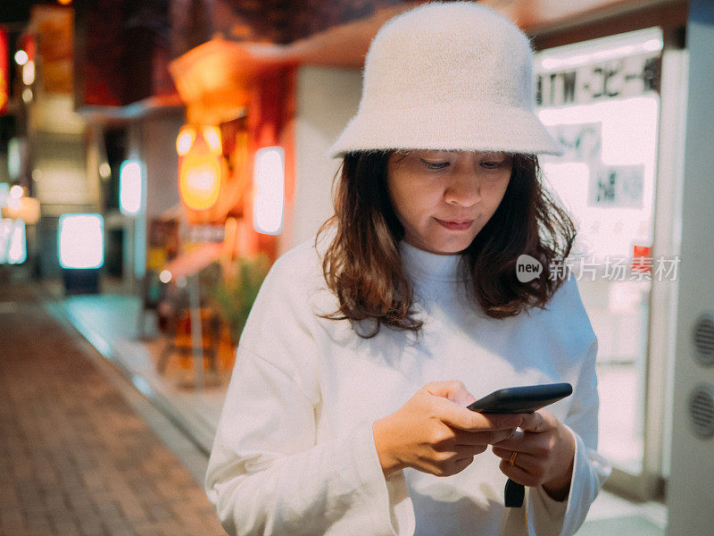 在日本，一个女人在户外发短信。