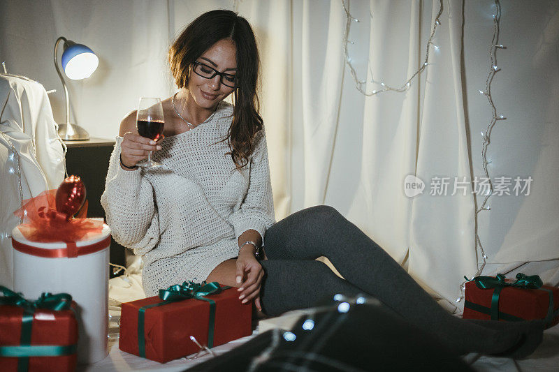 喝红酒，包装圣诞礼物的女人