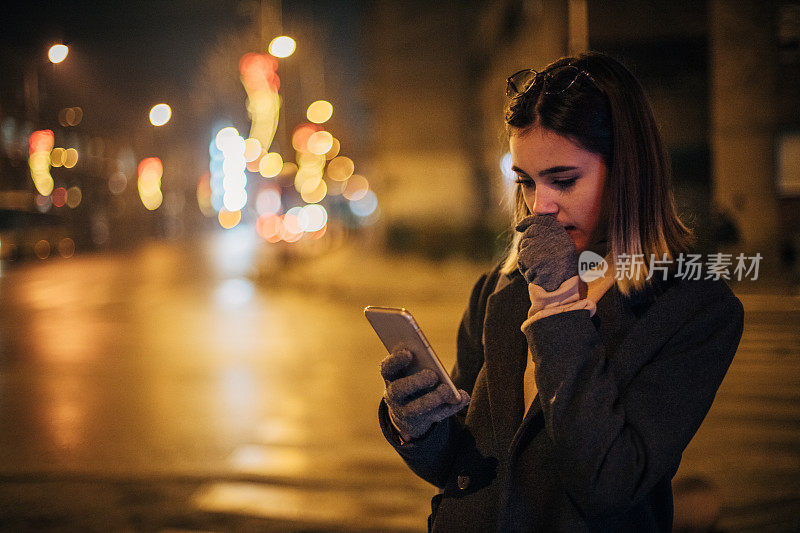 年轻女子在城市中使用手机