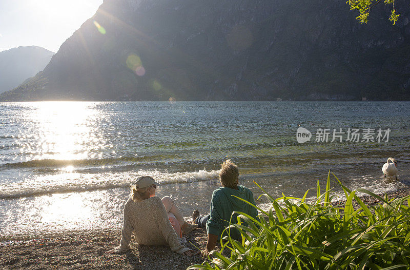 成熟的夫妇在海滩上放松，看外面的风景