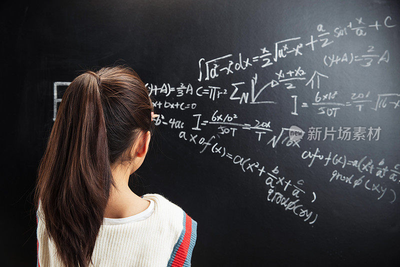 小女孩思考黑板上的数学题