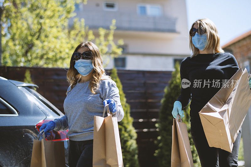 买菜回家的女人。戴上防护口罩和手套