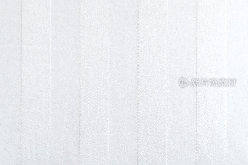 靠近白色褶皱褶皱条纹亚麻织物床单羽绒被纺织纹理背景在酒店度假。