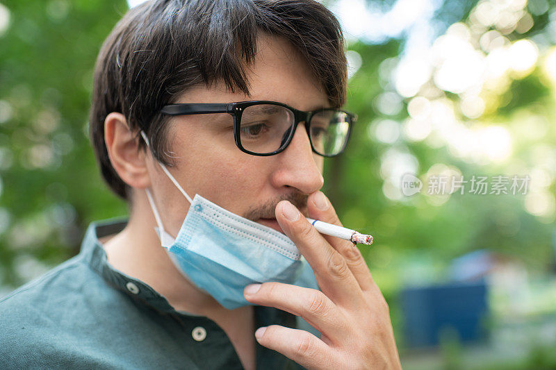 戴着防护面罩的男子夏天在户外吸烟