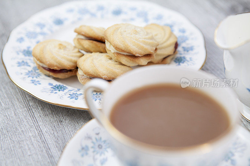 装饰的维也纳盘与茶杯和茶碟在一个轻木制表面旋转