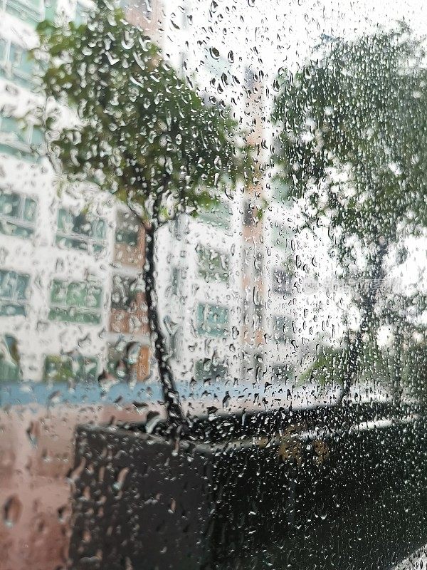 下雨的城市里看到的窗户被雨滴覆盖