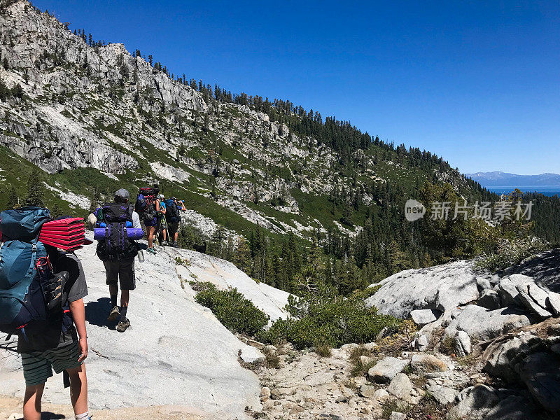 孩子和家长背包旅行，徒步进入加州的太浩湖的荒野