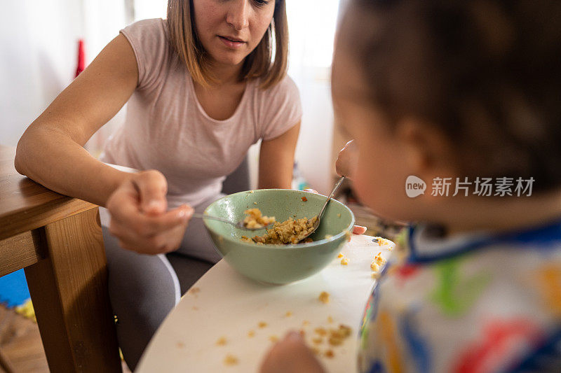 母亲在家喂她的小儿子