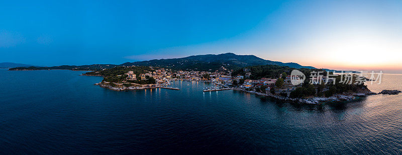 科孚，科克拉，夏季黄昏时仙后座的城镇和港口的航拍全景照片