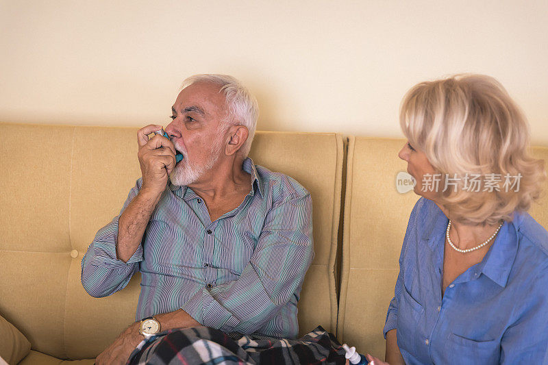 患有哮喘的老年男子有呼吸问题，所以他正在使用吸入器。