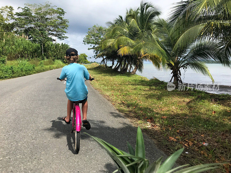 一个小孩喜欢在巴拿马海边骑自行车