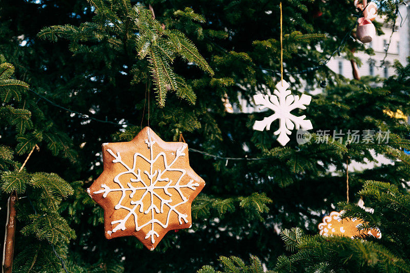 木制圣诞树玩具形状的星号在绿色的树枝上的圣诞树。