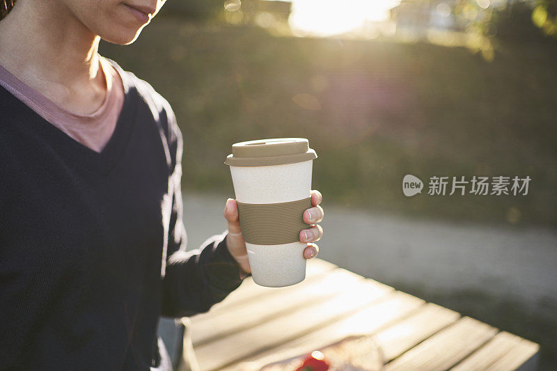 一个拿着可重复使用咖啡杯的女人