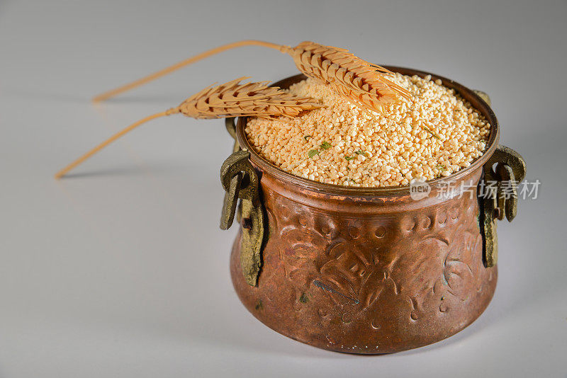 正宗汤碗里的Tarhana谷物。白色背景上的小麦和tarhana。小麦的耳朵。无谷蛋白厨房