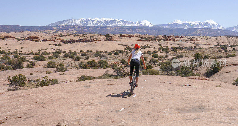 一名女性山地自行车手在早上沿着滑石小径骑行