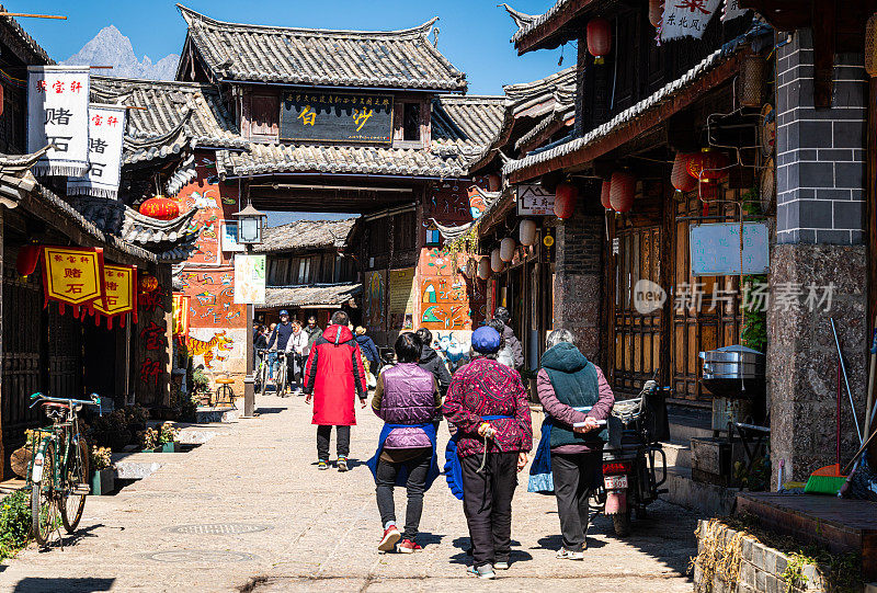 云南丽江附近，当地人走向传统的白沙纳西村大门