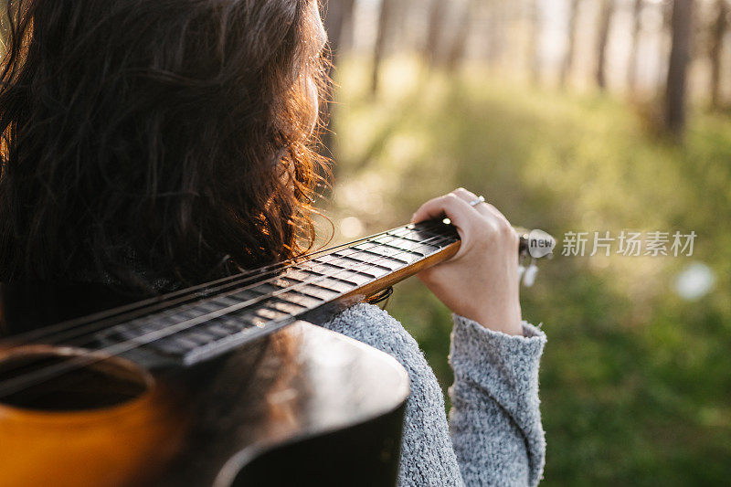 背着吉他的女孩在大自然中