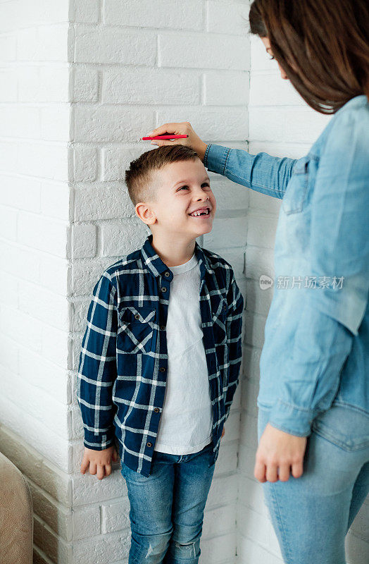 儿子母亲测量身高生长童年身高孩子身高孩子墙可爱快乐男孩测量父母生长
