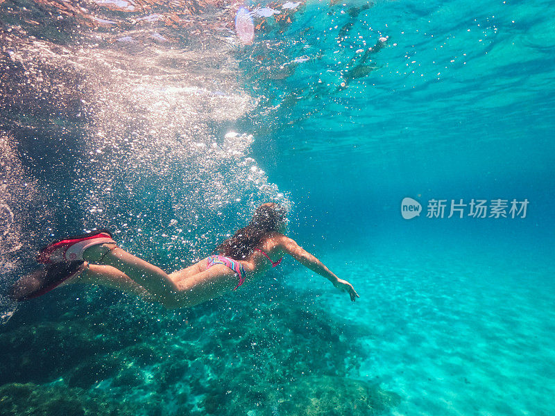 水下拍摄的一个年轻女孩浮潜在水晶蓝色的海洋