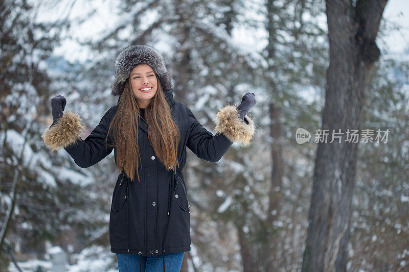 美丽的年轻女子在雪中享受