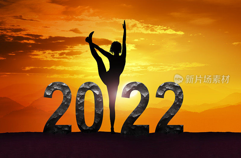 和日落时做瑜伽的女人祝2022年新年快乐