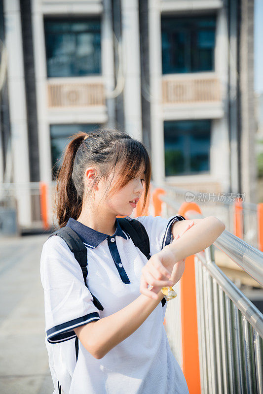 亚洲女孩在一个阳光明媚的日子放学回家