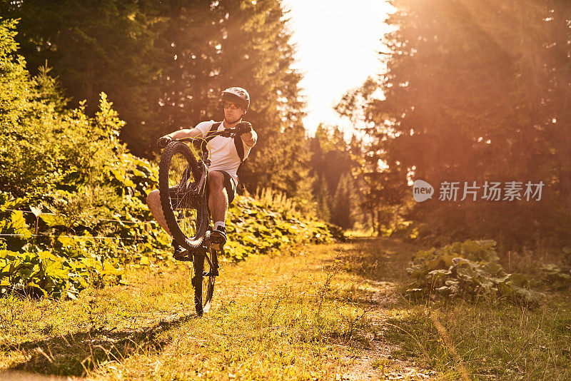 一个骑自行车的人骑在极端和危险的森林道路。有选择性的重点