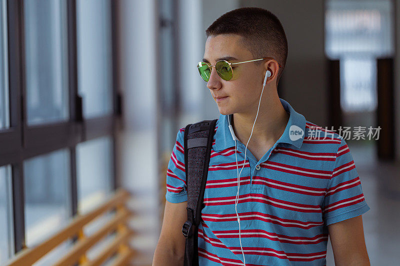 一名年轻男生离开高中大楼的画像