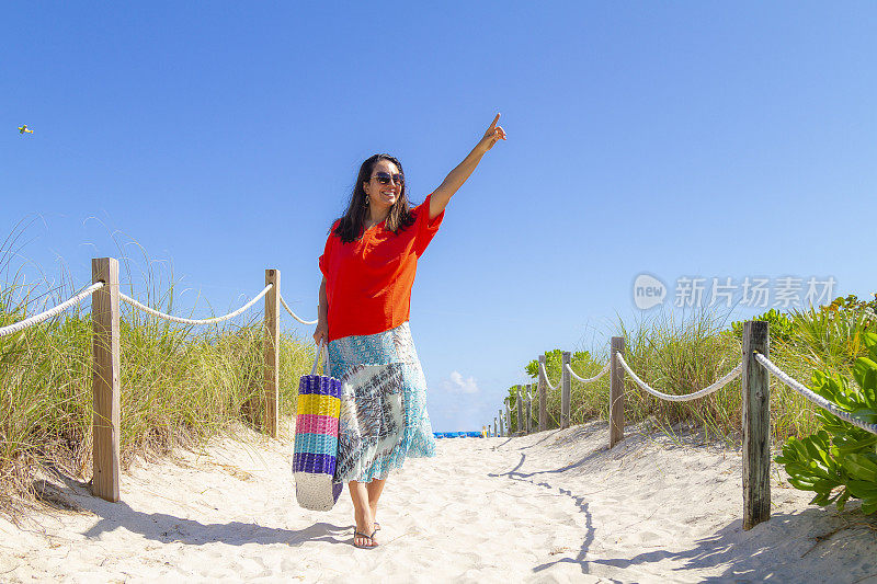 一名年轻的拉丁女子在世界著名的迈阿密海滩享受一日游，美国佛罗里达州南海滩，美国，阳光照亮在一个蓝色阳光灿烂的夏日中午。