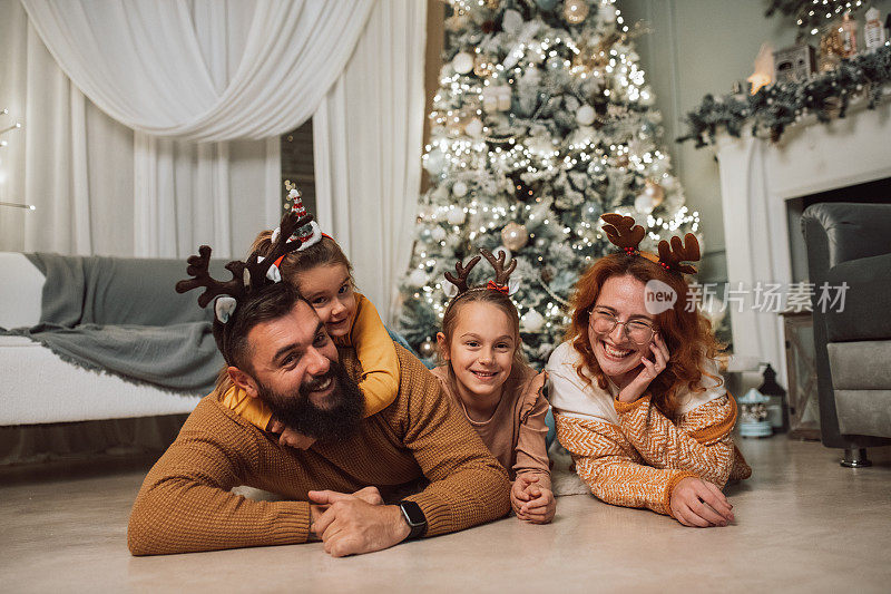 一家人在圣诞树前摆姿势的完美照片
