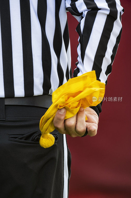一个美式橄榄球裁判抓着罚球旗